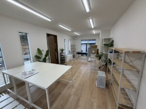 明るい木目調のフローリングと白い壁の事務所内観