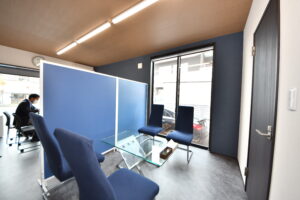 ブルーのパーテーションと木目調の天井が特徴的な落ち着いた応接室